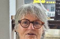 Foto einer Frau mit kurzen Gaaren, Brille und grauem Pullover