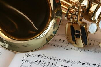 Foto eines Saxophon, das auf Notenblättern liegt