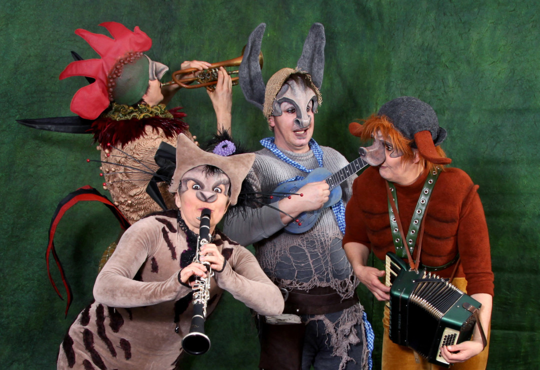 Foto von 4 Schauspielern als Esel, Hund, Katze und Hahn verkleidet mit ihren Musikinstrumenten